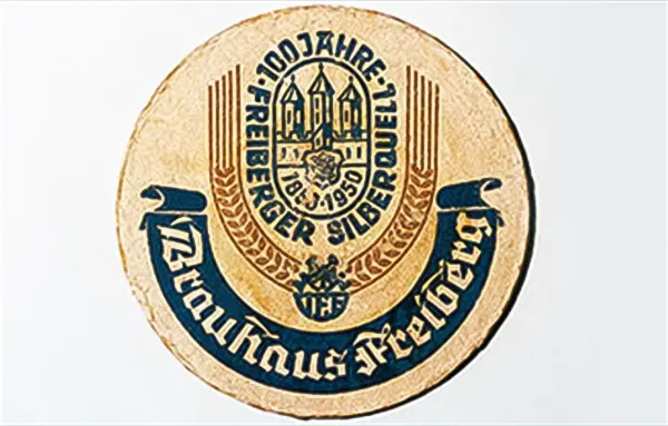 Runde Münze feiert 100 Jahre einer Prägemarke mit Inschriften und Symbolen.