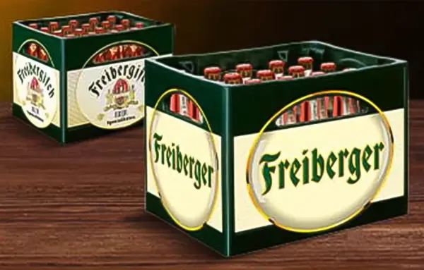 Zwei grüne Bierkisten mit Flaschen stehen auf einem Holztisch.