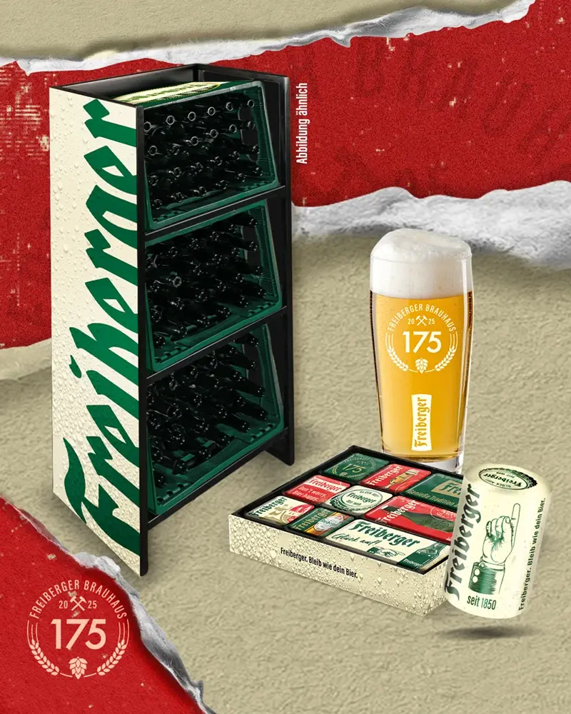Ein Glas Bier steht neben einem Getränkekasten und einer geöffneten Bierdose auf einem Tisch.